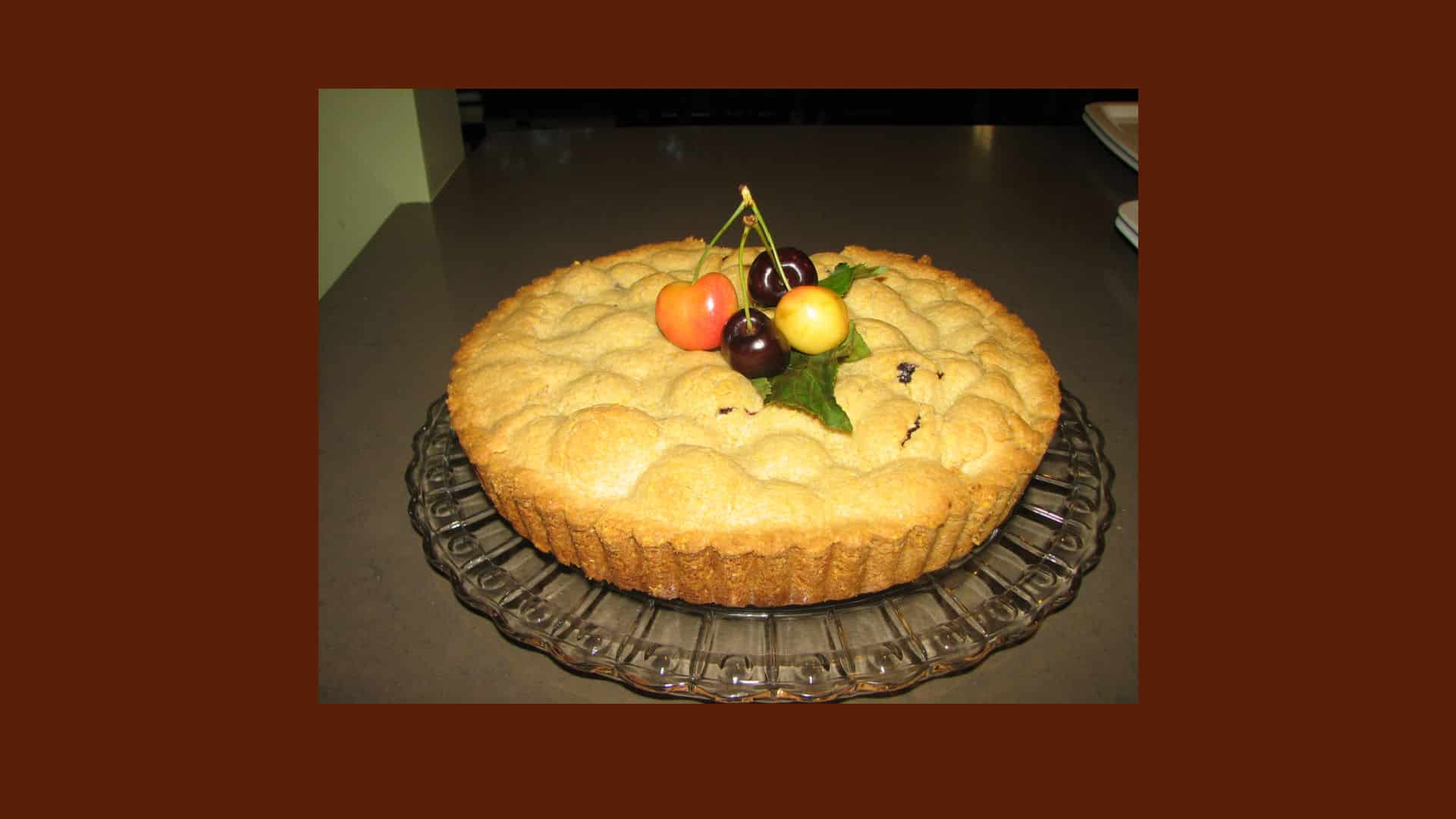 Cherry Tart a glass serving plate, burgundy background