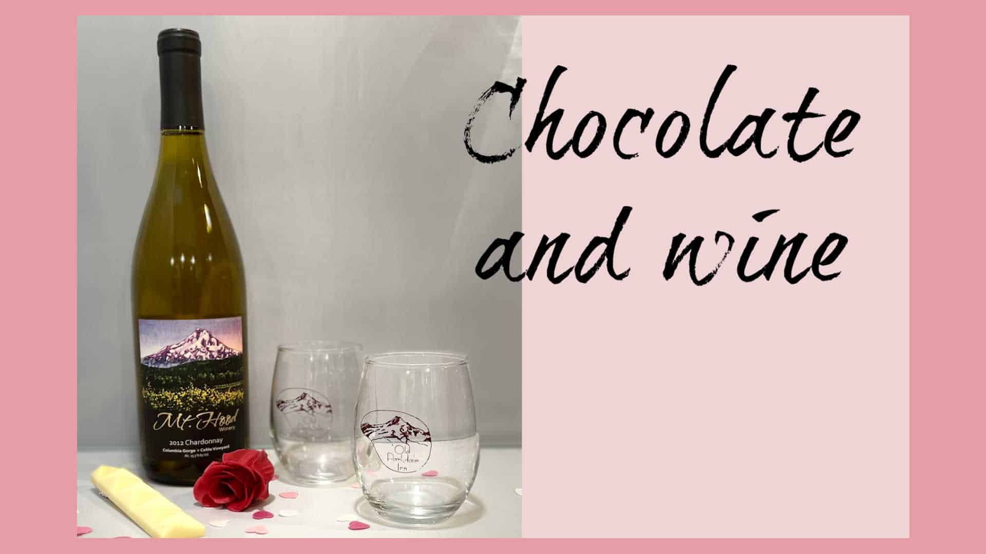 bottle of wine with 2 wine glasses, chocolate and rose petals