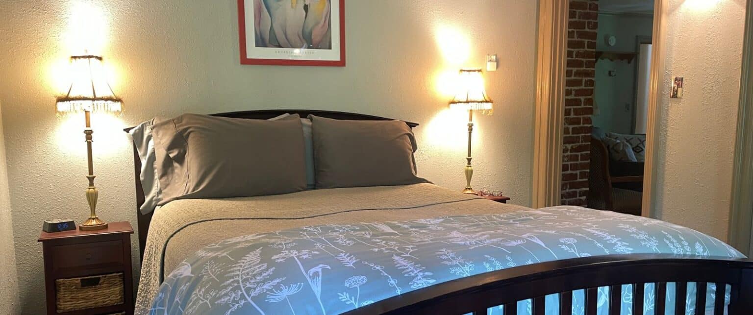 a bed with a wooden frame and a gray comforter